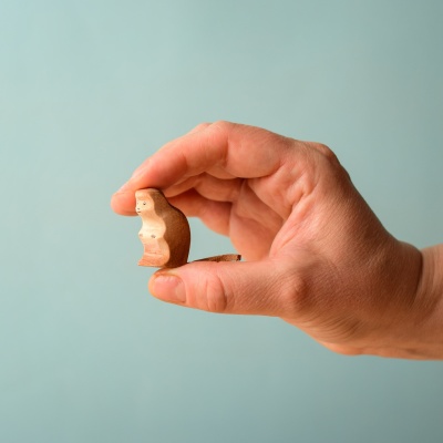 Hand holding the Baby Monkey wooden toy.