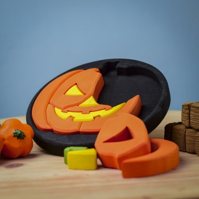 Round Halloween puzzle in a festive scene with other autumn decorations.