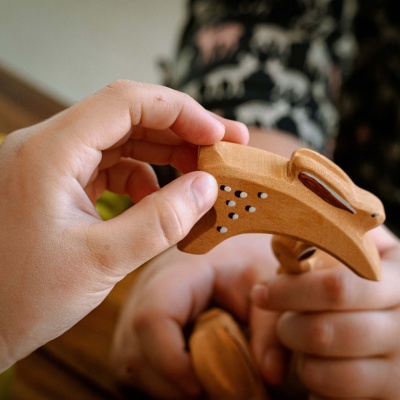 Child's hand playing with the running rabbit toy