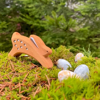 Running rabbit toy shown beside a child's wooden building blocks.