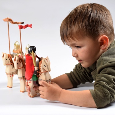 Close-up photo of a handcrafted wooden figure of Michael the Brave, a Romanian historical figure, wearing armor and holding a sword.