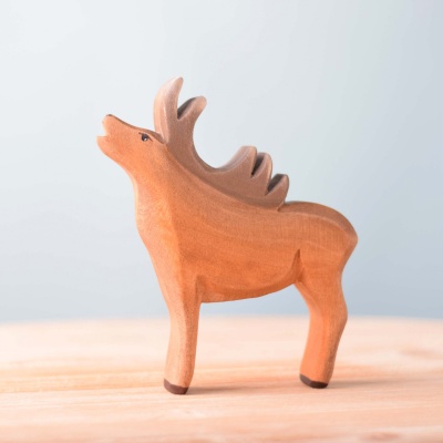 Close-up of the wooden stag toy's head, showcasing its detailed antlers and facial features.