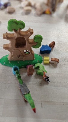 The open door of the treehouse showcasing furniture or small animals nestled inside.