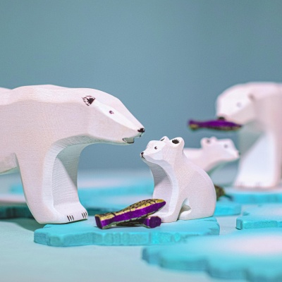 The Polar Bear peeking out playfully from behind a toy iceberg or snowy tree.