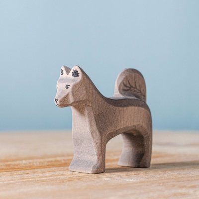 Image of a hand-carved wooden dog figurine named Shurik, sitting with its tail wagging and tongue lolling out.