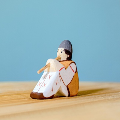 Bumbu Shepherd with Flute wooden toy standing on a rustic table.
