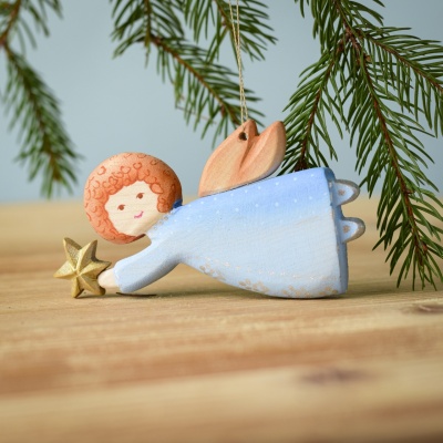 Handcrafted wooden Christmas Angel by BumbuToys lying with a star.