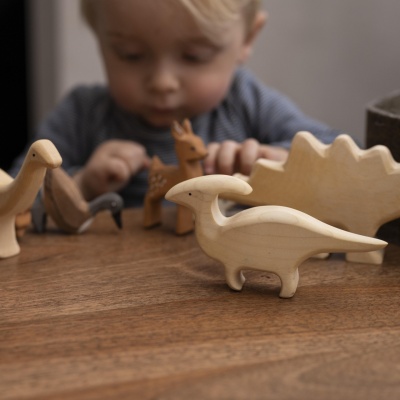 BumbuToys' Parasaurolophus dinosaur figurine standing proudly on a rustic wooden table.