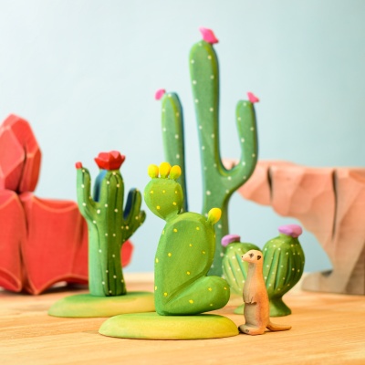 Wooden meerkitten with wooden cacti on a wooden surface