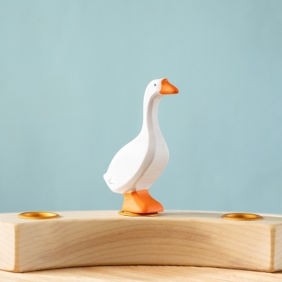 Single white handcrafted wooden toy goose figure standing upright on a tabletop