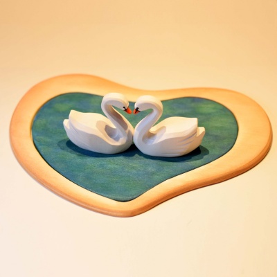 Romantic swan figures on a wooden lake, a testament to craftsmanship.