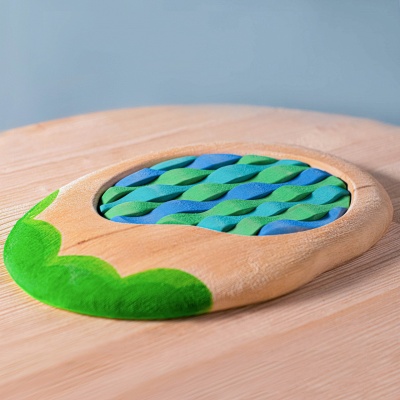Handcrafted puzzle pieces by BumbuToys come together to form a serene lakeside complete with cattails.