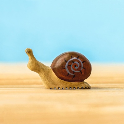 Close-up of a wooden snail figurine with detailed painting
