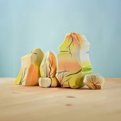 Colorful wooden Rainbow Rocks arranged in a nature-inspired setting.