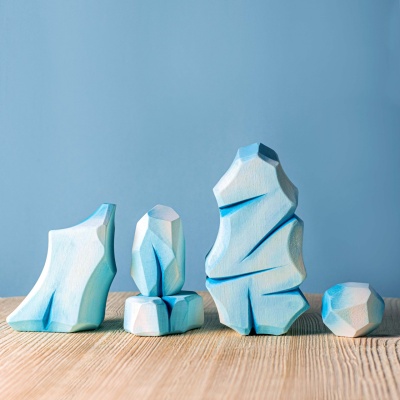 Artisanal wooden stones mimicking an icy terrain for creative play.
