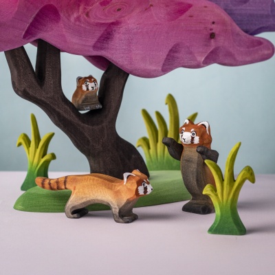 Red panda in imaginative forest setup with other animals
