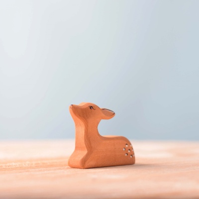 Artisanal wooden fawn figures in various postures.