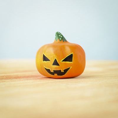 Medium wooden Halloween pumpkin with a jack-o'-lantern face.