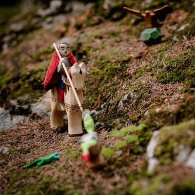 Child playing with St. George figure, imagining a battle.