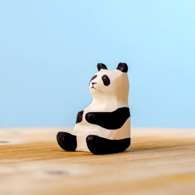 Side view of a wooden panda bear figurine with detailed painting