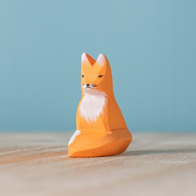 Close-up of the fox figurine, highlighting its detailed features and warm wood grain.