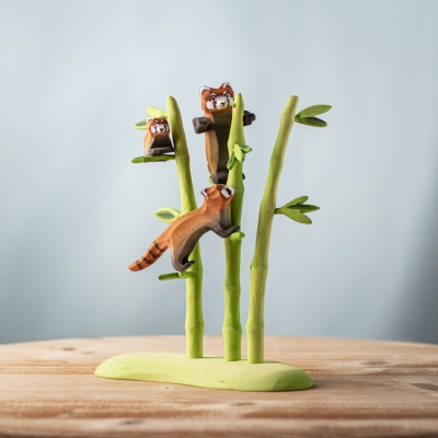 Red pandas climbing and playing around handmade bamboo toy