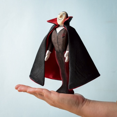 Hand holding the Count Dracula wooden figure, showcasing its size and detail.