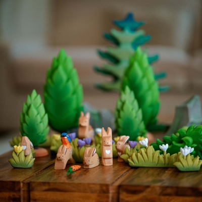 Child-safe wooden grass decoration with a white flower.