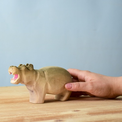 Wooden Hippo toy being held in a hand.