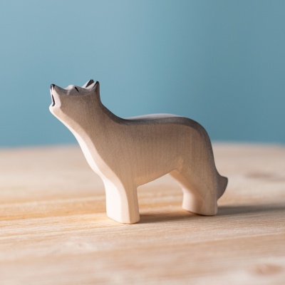 The howling wolf standing next to other Bumbu wooden animals, such as a bear, deer, and owl.