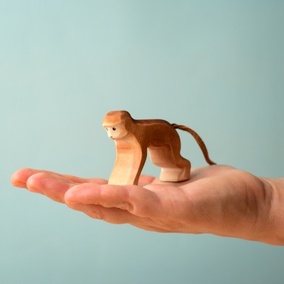 Hand holding the Monkey wooden toy.