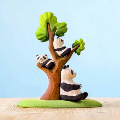 Wooden panda bears playing around a wooden tree
