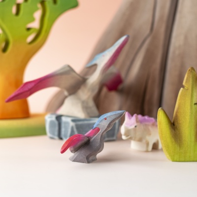 Baby Pteranodon in prehistoric play scene with volcano and friends