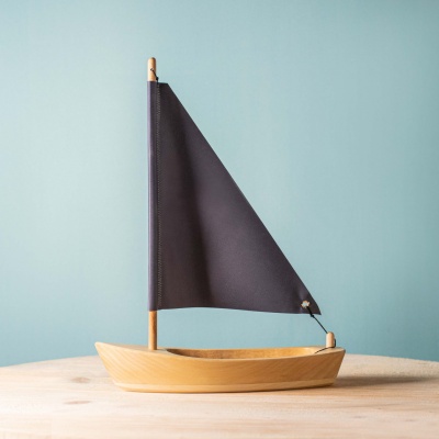 BumbuToys' handcrafted wooden sailing boat with a dark anthracite sail.