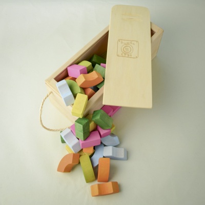 Child using blocks to spell out their name with a joyful expression.