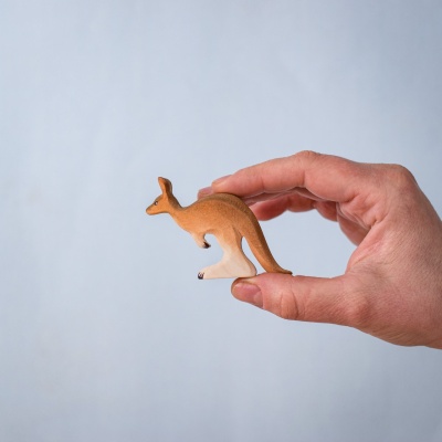 Young kangaroo toy held in hand to show scale