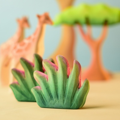 Savanna bushes with giraffes and acacia trees in a play scene.