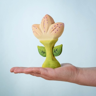 Close-up of Spring Flower - Zia wooden toy with peach and purple petals, held in a hand, showcasing its eco-friendly, handcrafted design.
