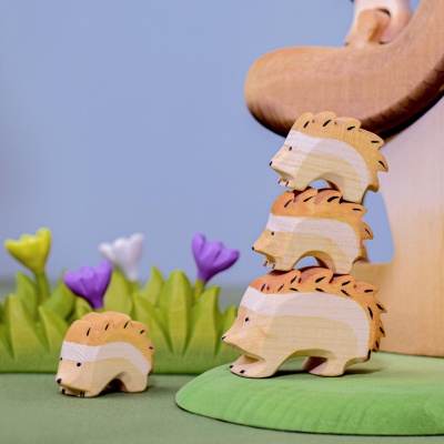 The toy incorporated into a sensory bin with natural materials like leaves, twigs, and pebbles.