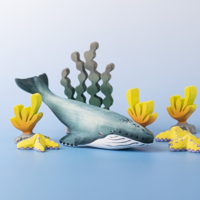 Blue Whale toy placed in a coral reef scene with yellow sea plants