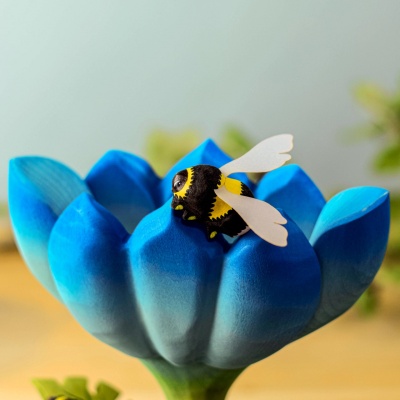 Bumblebee figurine near a wooden plant base