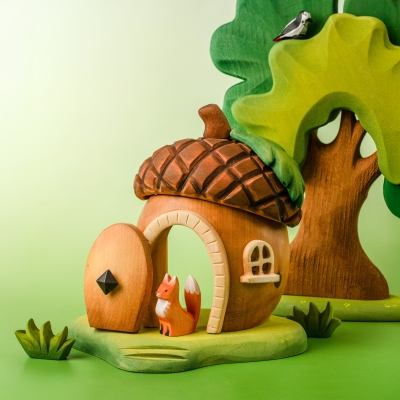 Close up of child hands opening the tiny wooden door of the handcrafted acorn house toy