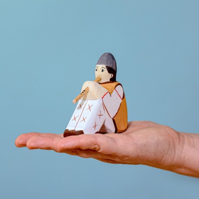 Child holding the Shepherd with Flute toy, pretending to play a tune.