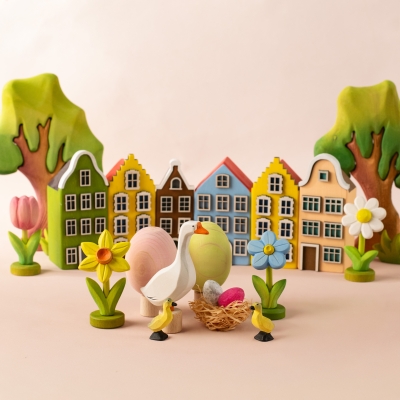 Colorful wooden village scene with a goose ducklings and a blue toy forget-me-not