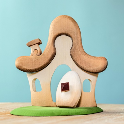 A whimsical wooden hut from BumbuToys, designed to spark creative storytelling in a forest setting.