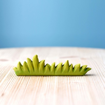 Close-up of Large Grass wooden toy, showcasing its natural wood grain and texture.