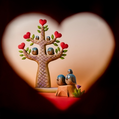 Valentine's Day scene with wooden birds framed by a heart-shaped shadow.