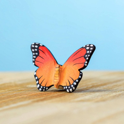 Hand-carved wooden butterfly toy on a wooden surface
