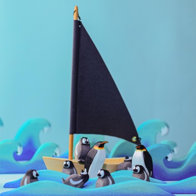 A family of penguins from BumbuToys standing proudly on their wooden ice floe, a scene that captures the heart of the polar landscape.