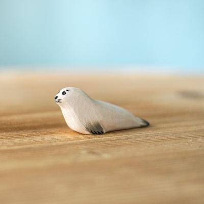 Side profile of a handcrafted wooden seal pup showing natural wood grain and safe paint.